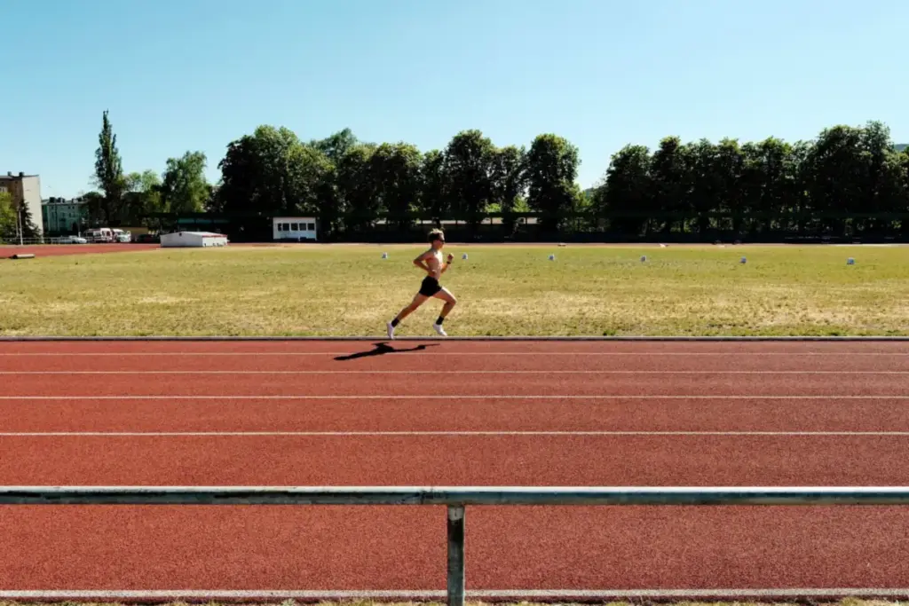 Aspirante corriendo en una pista de atletismo al aire libre