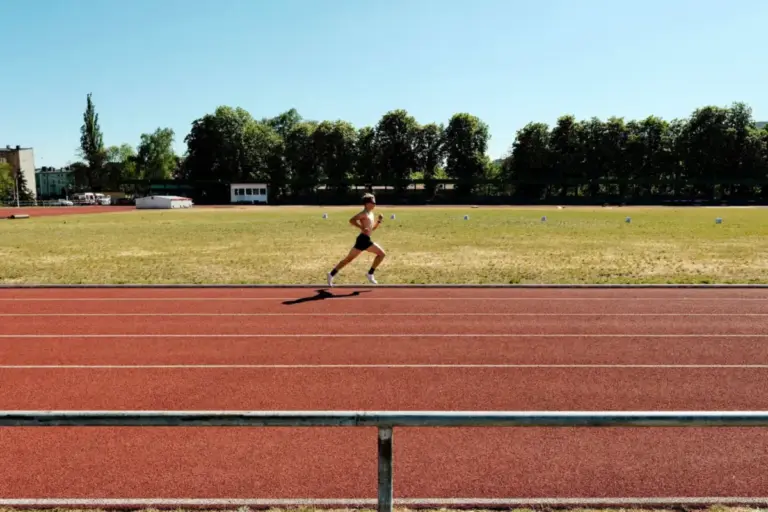 Aspirante corriendo en una pista de atletismo al aire libre