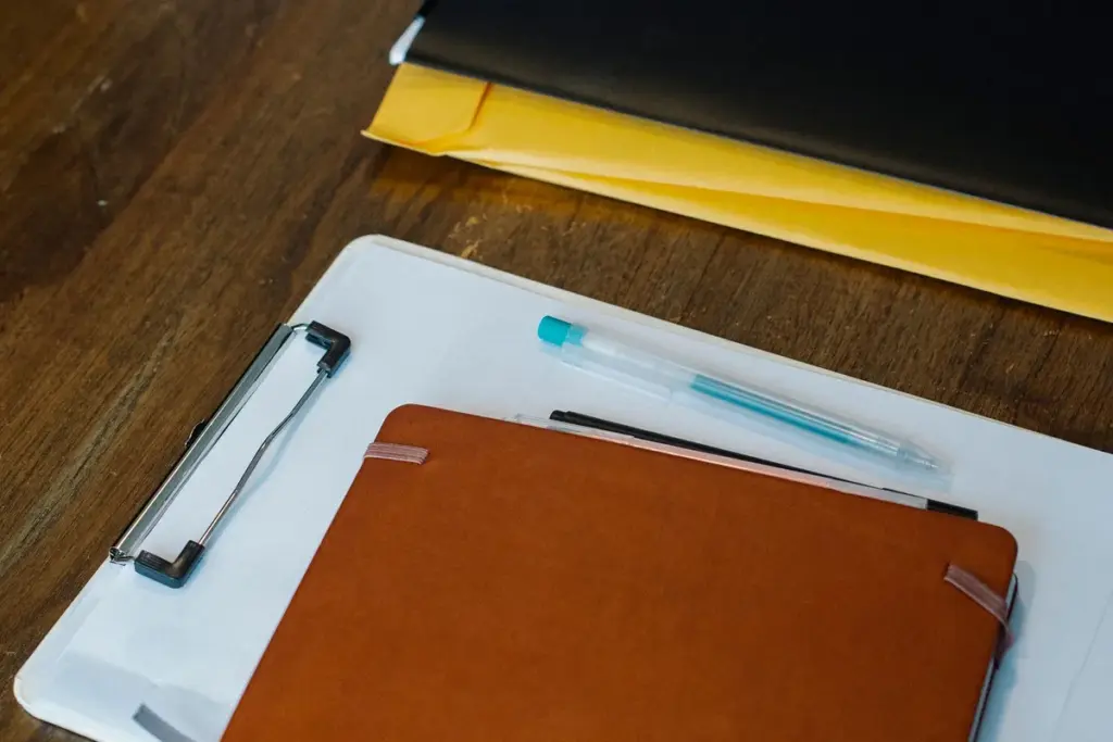Carpetas, documentos y bolígrafo ordenados sobre un escritorio