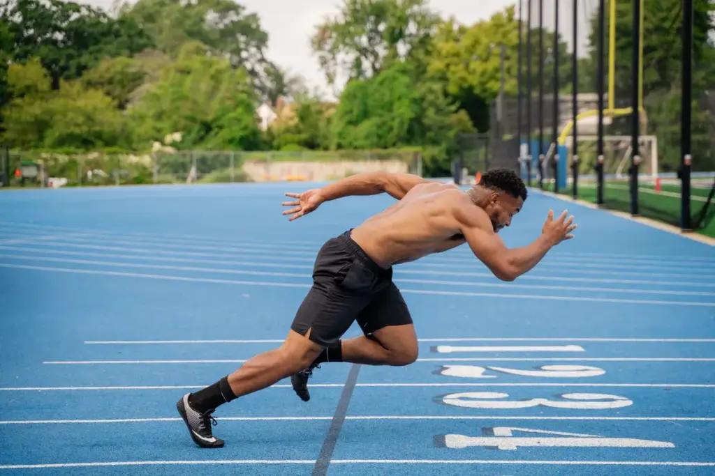 Joven entrenando en una pista de atletismo para la prueba física