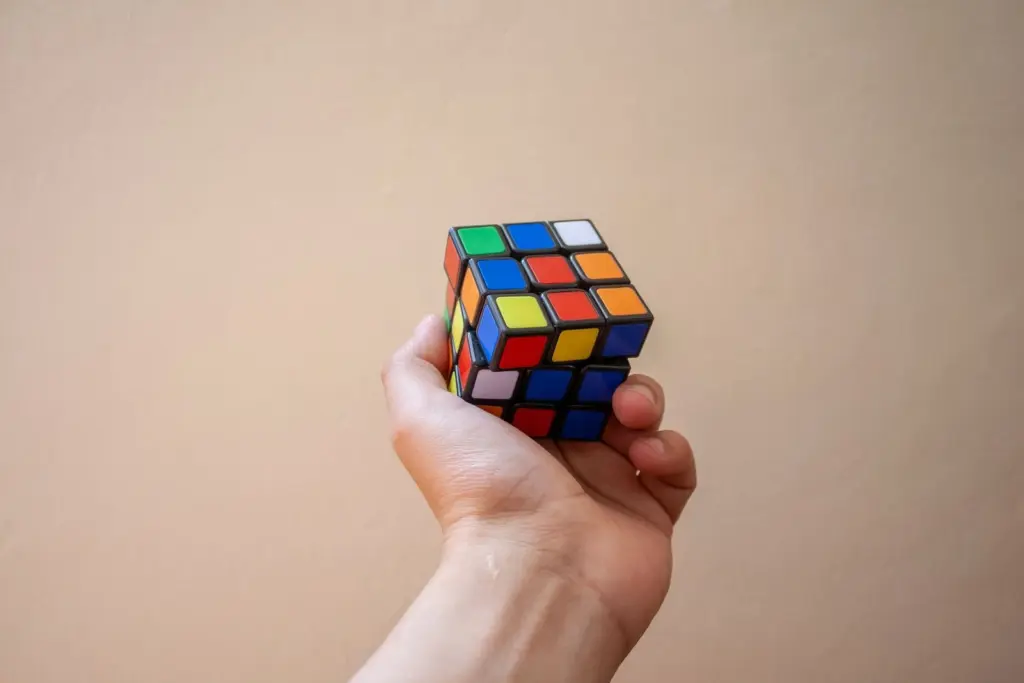 Mano sujetando un cubo de colores a medio resolver