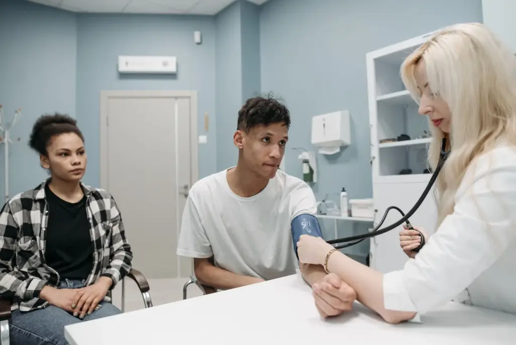 Médico tomando la tensión arterial a una persona joven