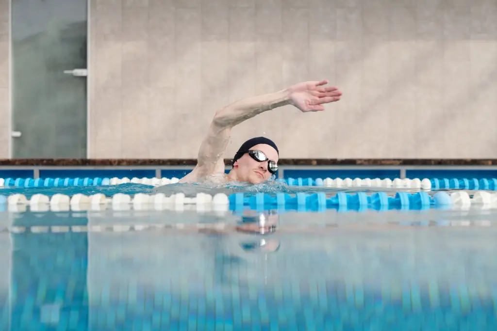 Nadador entrenando crol en una piscina cubierta