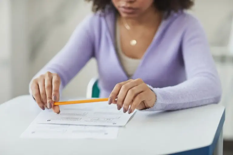 Opositora rellenando un cuestionario con lápiz en una sala de examen