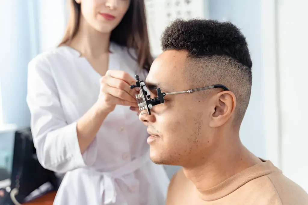 Optometrista revisando la vista de un paciente con una montura de pruebas